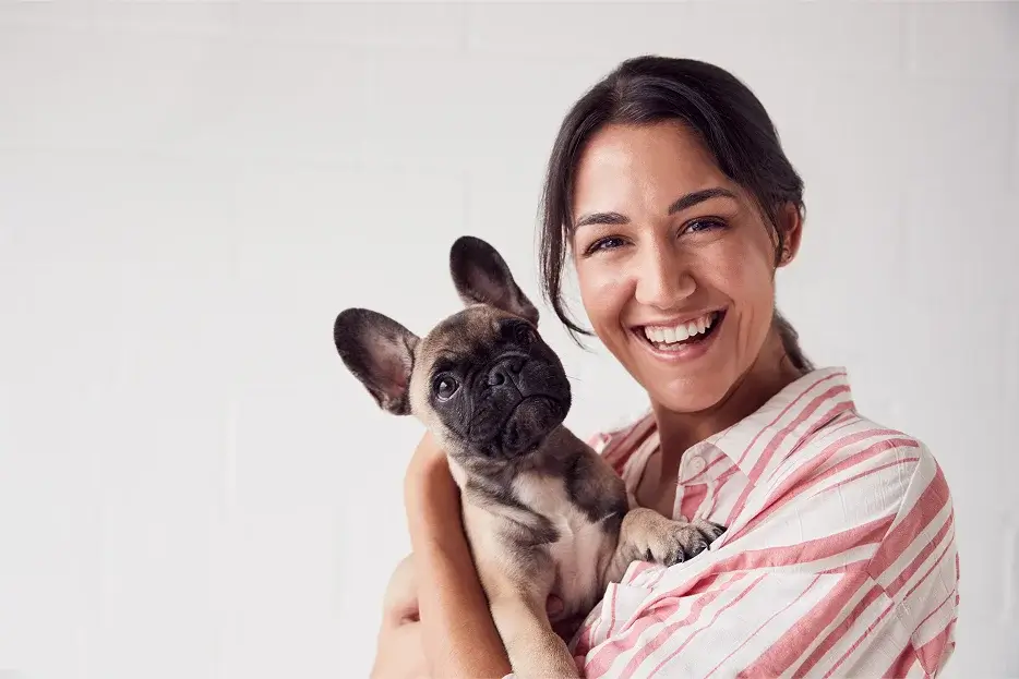 Woman holding a newborn Frenchie after adopting